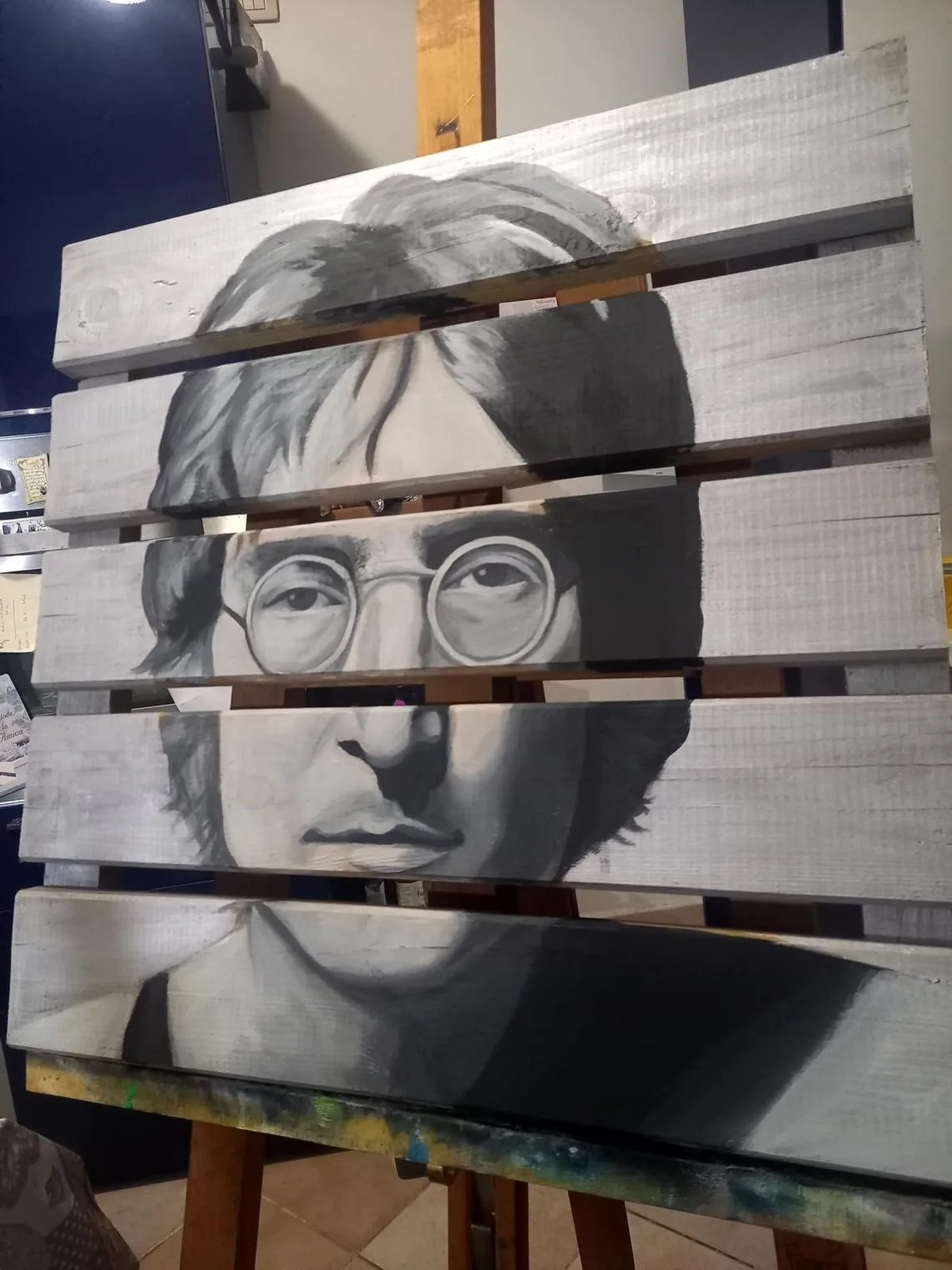 John Lennon dipinto in bianco e nero su un bancale di legno